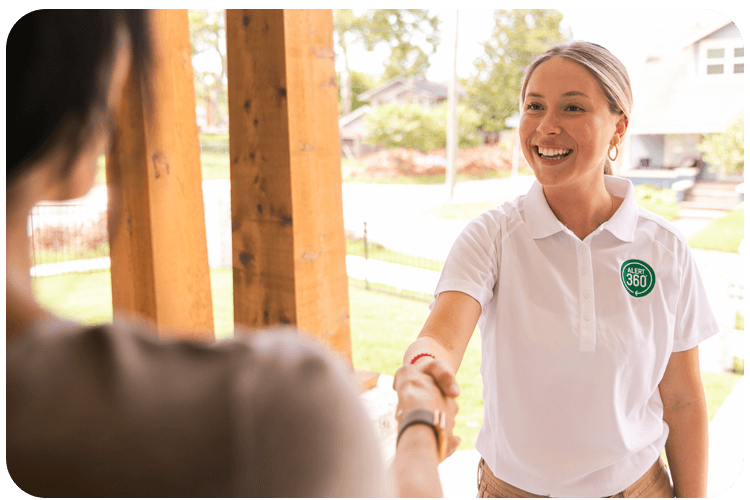 Smiling Alert 360 representative shaking hands with customer