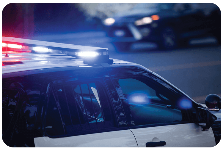 A police cruiser with emergency lights on, positioned near a roadway in Phoenix, AZ.