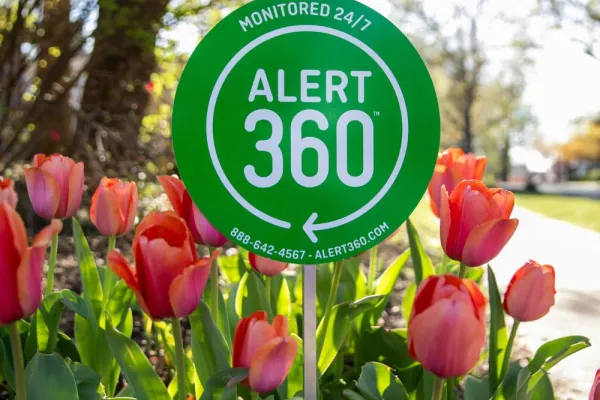 Alert 360 Yard Sign surrounded by tulips