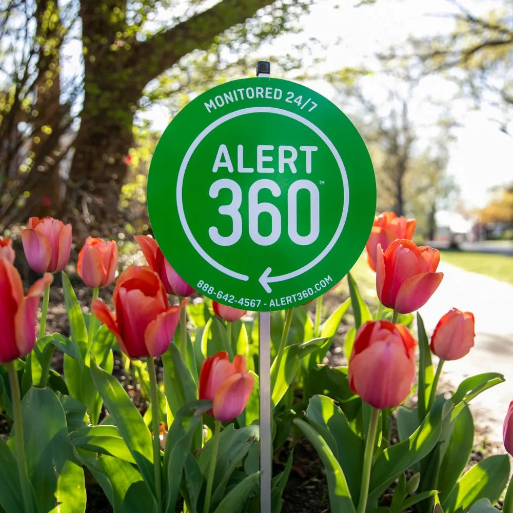 Alert 360 Yard Sign surrounded by tulips